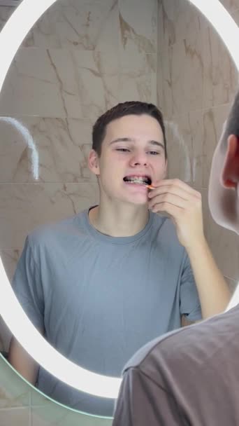 Teen Čistí Jeho Závorky Před Zrcadlem Koupelny — Stock video
