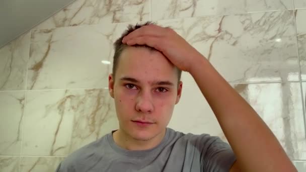 Prøver Håret Hans Til Attraktivt Tenåringsgutt Fikser Håret Med Hendene – stockvideo