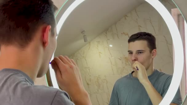 Teenage Boy Tričku Čistí Zuby Před Zrcadlem — Stock video