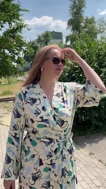 Young Woman Wearing Sunglasses Fixes Her Blowing Hair — Stock Video