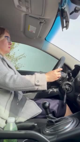 Blonde Frau Mit Brille Fährt Auto Durch Die Stadt — Stockvideo