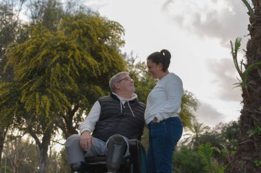 Parkta aşık bir çift, iki bacağını da kaybetmiş ve tekerlekli sandalyede olsa bile aşka dayanır..