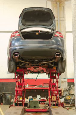Yüksek lüks araba, atölye asansöründe servis edilmeyi bekliyor.