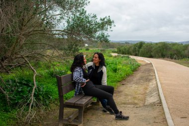 Anne ve kızı parkta tecrübelerini paylaşıyor.