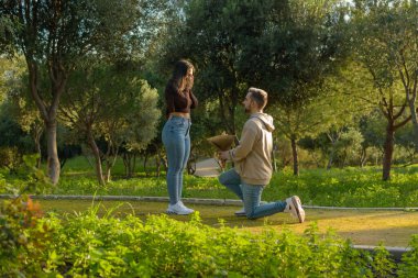 she can't contain her surprise when she sees the beautiful bouquet of flowers that her date gives her on valentine's day.