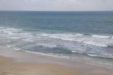 Yumuşak dalgalı ve ferahlatıcı okyanus esintili boş bir sahil.