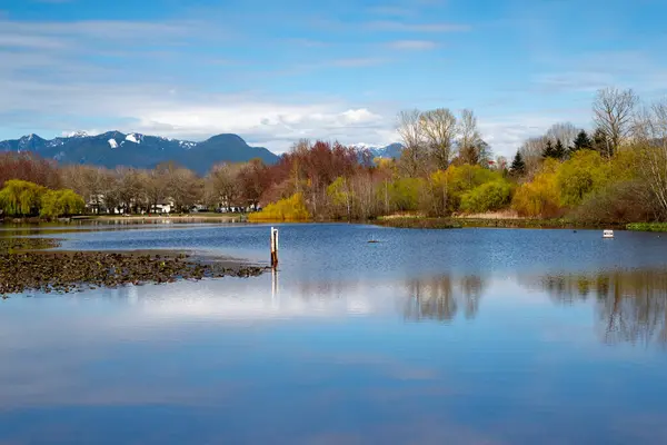 Dağların yansıması ve mavi gökyüzü ile göl. Güzel bahar manzarası.