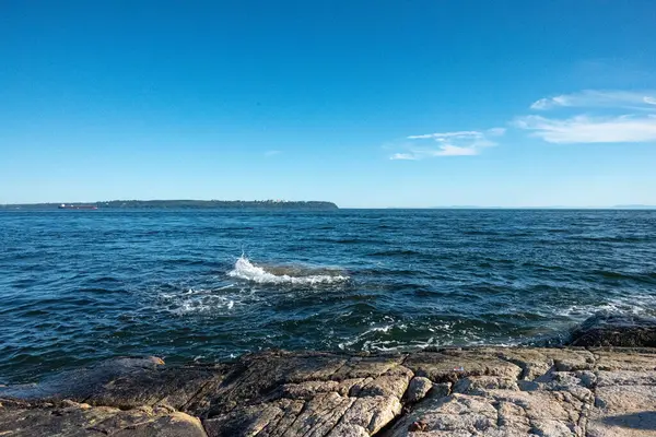 Arka planda mavi gökyüzü olan Kanada Denizi 'nin Rocky sahili.