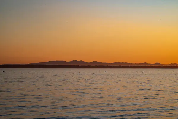 Kanada, White Rock 'ta günbatımı. Güneş dağların ardında batıyor..