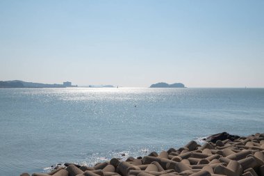 Ön planda tetrapodlu deniz manzarası ve arka planda deniz manzarası