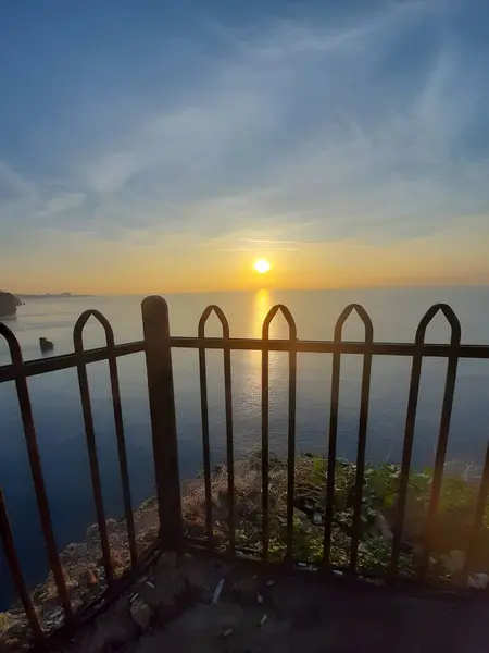 Sunset A Peaceful and Romantic Evening View through the Iron Fences by the Sea