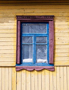 Evin sarı duvarındaki eski ahşap pencere..