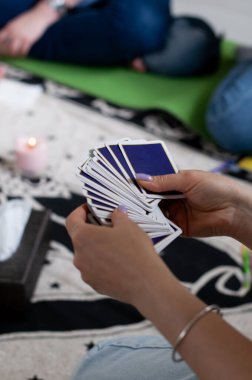 Bir kadın elinde bir deste mavi kart tutuyor.