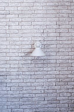 Beyaz lamba evin iç tarafındaki tuğladan bir duvarda.