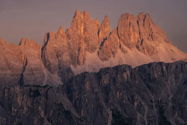 Dolomite Mountains peaks lighten by late afternoon sun light blowing peaks in warm red colors with the cloudless sky