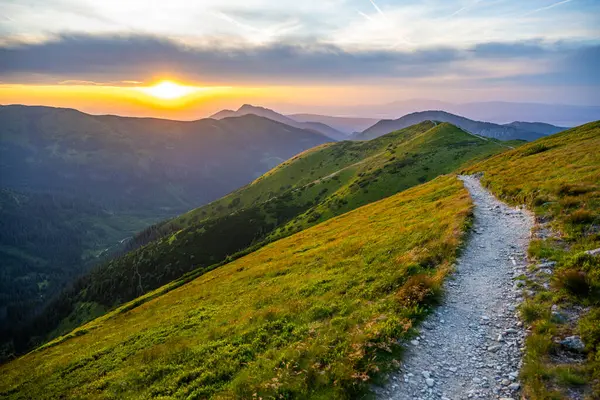 Hikknig path in the mountains during beautiful summer sunset.