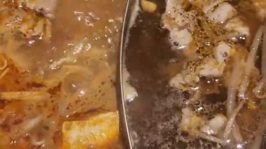 Shabu-shabu tenceresi iki bölüme ayrılır, her biri farklı bir lezzet içerir, böylece bir tabakta çifte lezzet deneyimi yaşayabilirsiniz.