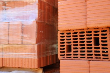 Paletlerde seramik tuğlalar. Felç olmuş inşaat malzemesi. Ev ve binaların inşaatı için tuğlalar. İnşaat, inşaat, mimari çalışmaları, kentsel planlama kavramı. Kırmızı tuğla.