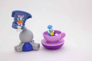 Daisy Duck bir uçuş oyununda ve dönen bardakta dönen Donald Duck Disney 's parkında. Lunaparktaki çizgi film karakterleri. İzole edilmiş beyaz arka plandaki çocuklar için toplanabilir oyuncaklar