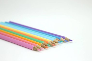 Pastel renklerle çizim yapmak için kalemler. Beyaz arka plandaki okul malzemeleri izole edilmiş ve mesajlar için boş alanı var. Okullar, öğrenciler ve illüstratörler için suç ortağı.