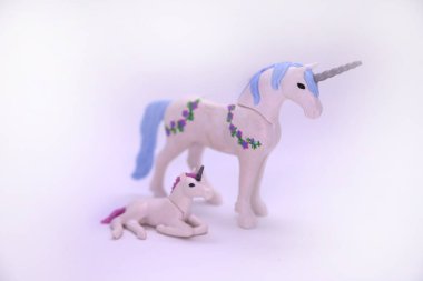 Oyun arabası. Çocuklar için oyuncaklar. Plastik tek boynuzlu atlar. Tek boynuzlu efsanevi hayvanlar. Harika hayvanlar. Hayal gücü. Anne ve oğlu. İzole edilmiş beyaz.