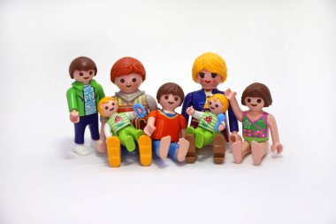 Büyük bir aile. Baba, anne, oğullar ve kızlar. Üçüzler ve ikizler. Oyuncak bebekler. Oyuncaklar, rakamlar. Mutlu aile fotoğrafı. Beyaz arka plan. İzole edilmiş.
