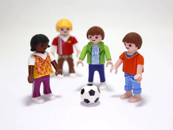 Oyuncak bebekler. Çocuklar futbol oynuyor. Küçük kızlar ve oğlanlar dışarıda spor yapıyor. Arkadaşlar eğleniyor ve mutlular. Maç zamanı. İzole edilmiş beyaz.