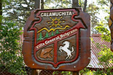 Wooden sign with the coat of arms of the city of Villa General Belgrano in Calamuchita. Cordoba, Argentina. Carved poster. National capital tourist city of Oktoberfest beer festival. clipart