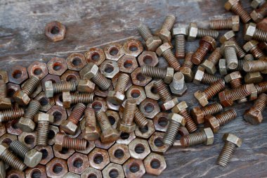 Paslı fındık, vida ve civata. Kirli. Eski model. Yaşlandım. Paslı metal parçaları birbirine uyuyor. Makine yapmak için nesneler. Elle çalışma tablosu.