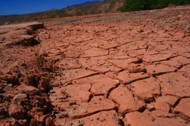 Desert. Cracked earth. Red land. Clay. Desert soil. Dry ground. Broken ground. Argentine North. Argentina. Path of the Calchaquies Valleys. Drought. Lack of water. Enviroment. clipart