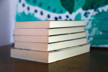 Kitaplar. Bir yığın kitap. Romanlar. Edebiyat. Okuyorum. Genel kitaplar. Kağıt kitaplar. Soyut resim arkaplanı. Tahta masadaki kitaplar..