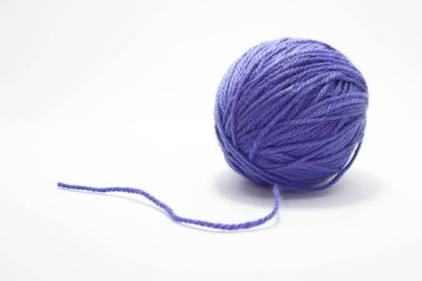 Mor yün derisi. Leylak. Örgü örmek için iplik. El örgüsü. Kumaş. Koyun tüyü derisi. Kalın yün. İki iğneyle örmek için yün. İzole edilmiş beyaz. Mor mavi örgü ipliği. 