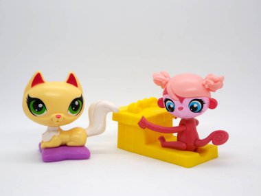 Littlest pet shop. Kitten with big green eyes on her pillow. Monkey with big blue eyes with a gift. Toy for girls and boys. McDonal's happy meal toy. clipart