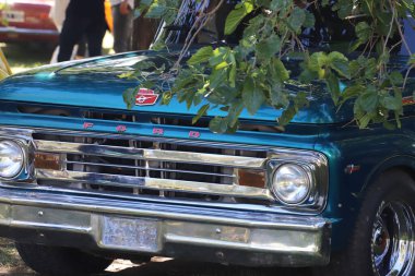 Eski metalik mavi Ford F100 kamyonu. Eski klasik arabaların açık hava sergisi.