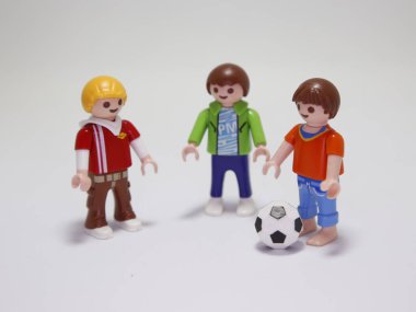 Oyuncak bebekler. Çocuklar futbol oynuyor. Küçük çocuklar dışarıda spor yapıyor. Arkadaşlar eğleniyor ve mutlular. Maç zamanı. İzole edilmiş beyaz.