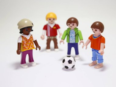 Oyuncak bebekler. Çocuklar futbol oynuyor. Küçük kızlar ve oğlanlar dışarıda spor yapıyor. Arkadaşlar eğleniyor ve mutlular. Maç zamanı. İzole edilmiş beyaz.