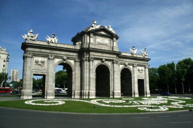 Madrid İspanya. Puerta de Alcala 'nın panoramik manzarası. Turist eğlencesi. Ünlü İspanyol anıtı. Gerçek Puerta Plaza de la Independiencia kavşağında yer almaktadır..