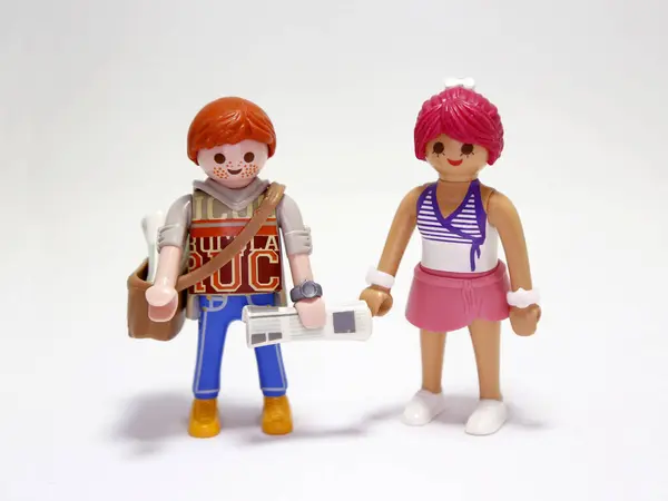 stock image Playmobil doll. New's paper seller. Young boy. Paperboy. Newspaper. Redhead with freckles. Boy and girl. Couple. Happys persons. Isolated white. Toys.