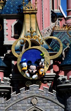 Mickey 'nin kulaklarında Mickey Mouse, Donal Duck, Goofy ve Pluto karakterleriyle Euro Disney Castle. Walt Disney karakterleri. Disney parkları. Disney 'in büyüsü. Disney Land Paris 'te. Seyahat.