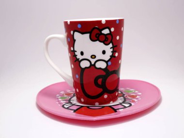 Merhaba Kitty karakter kupası ve tabağı. Seramik bardak. Ünlü bir karakter. Sevimli kedi yavrusu. Japonya 'dan bir karakter. Ünlü Japon kedi yavrusu. İzole edilmiş beyaz. Sıcak içeceğe itirazım var. Kalp şeklinde plaka..