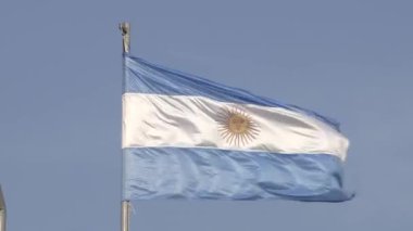 Arjantin bayrağının rüzgarda dalgalandığı yüksek çözünürlüklü bir video. Arjantin 'in açık mavi ve beyaz bayrağı. Ulusal sembol. Mavi gökyüzü.