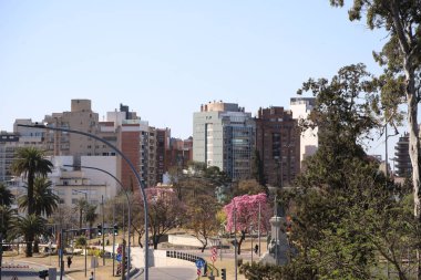 Arjantin 'in Crdoba şehrinin kentsel manzarası. Park Sarmiento manzaralı bir cadde ve apartmanlı bir arka plan. İnsanlar ve arabalar sokaklarda geziyor..