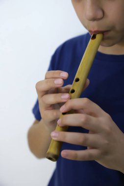 Latin çocuk Hint flütü çalıyor. Latin Amerika rüzgar enstrümanı çalan müzisyen.