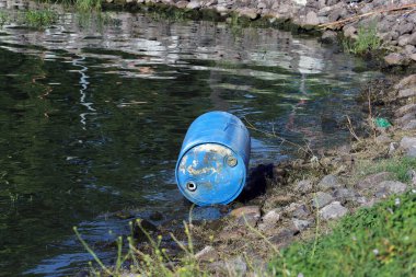 Su kirliliği. Gölün kıyısına zehirli kimyasallar döküldü. Zehirli atık maddelerle dolu bir varil suya atılmış..