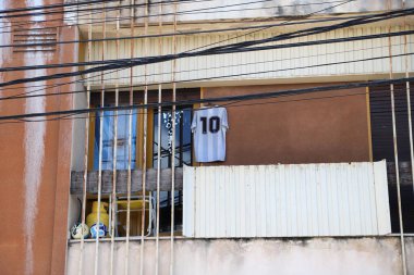 Balcony of house with flag, shirt and soccer balls of the Argentine national team. Lionel Messi number 10 shirt. clipart