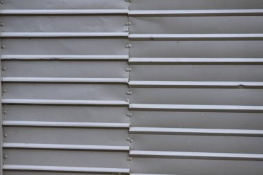 Endüstriyel dokusu ve görünür perçinleri olan gri metal panellerin yüzey arka planı.