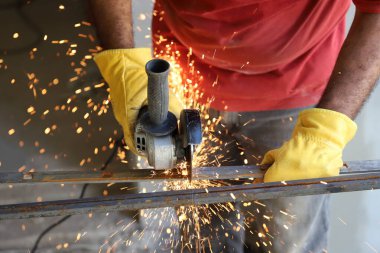 Demirleri öğütücüyle kesen işçiler kıvılcımlar üretir.