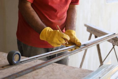 Demirci yapı için metali ölçüyor. Endüstriyel işlerde mezura kullanan bir adam.