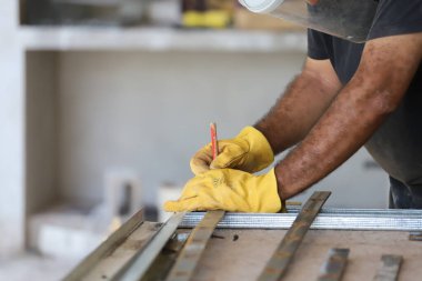 Kesim için işaretleme metali üzerinde çalışan adam