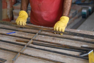 Demirci demir çit yapmaya çalışıyor.